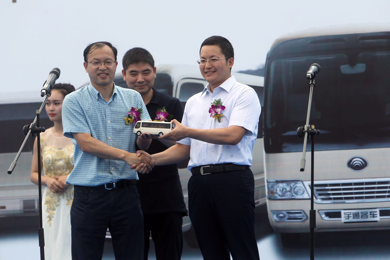 宇通領(lǐng)導(dǎo)（右一）向客戶贈予T7車模